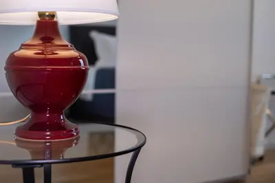 a red vase sitting on top of a glass table at ht siesta sistina in Rome