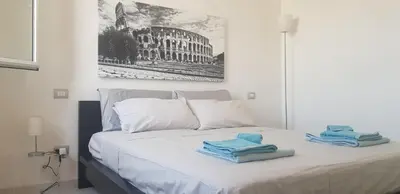 a white bed with towels on top of it at Attico Porta Furba Rome in Rome