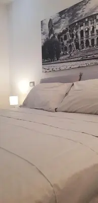 a white bed in a bedroom with a picture on the wall at Attico Porta Furba Rome in Rome