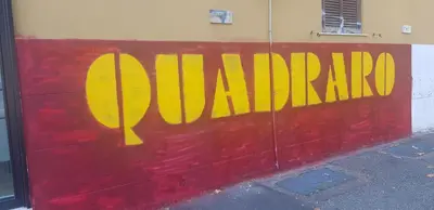 a red wall with the word apartheid painted on it at Attico Porta Furba Rome in Rome