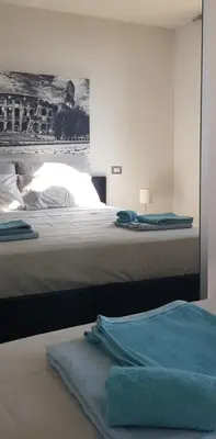 a bedroom with a bed with a blue towel on it at Attico Porta Furba Rome in Rome