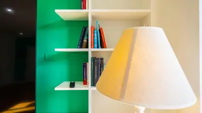 a white book shelf with a lamp and books at Villa Paolina by Rentbeat in Rome