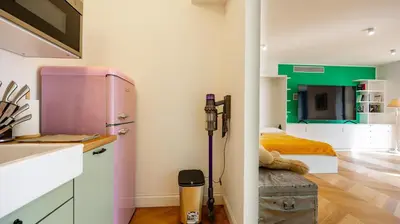 a kitchen with a pink refrigerator and a bed at Villa Paolina by Rentbeat in Rome