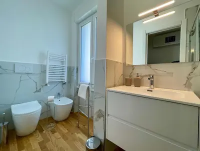a white bathroom with a sink and a toilet at Metro Marconi - University quarter apartments in Rome