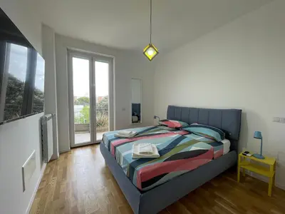 a bedroom with a bed and a large window at Metro Marconi - University quarter apartments in Rome