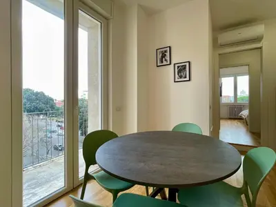 a dining room with a table and chairs and a large window at Metro Marconi - University quarter apartments in Rome