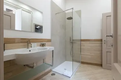 a bathroom with a sink and a glass shower at Roma - Parione House in Rome