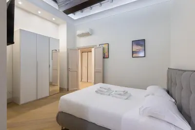 a white bedroom with a bed and a mirror at Roma - Parione House in Rome