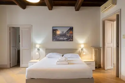 a bedroom with a large white bed with two lamps at Roma - Parione House in Rome