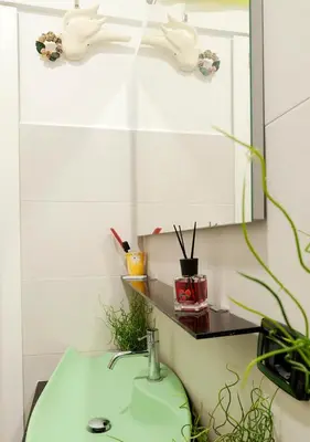 a bathroom with a green sink and a mirror at Plumeria Bianca in Rome