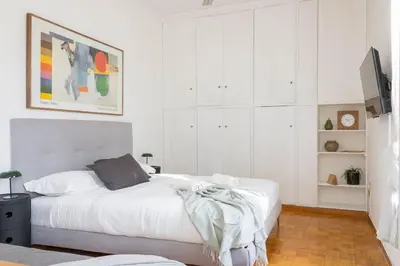 a white bedroom with a white bed and white cabinets at Governo Central Apartment in Rome