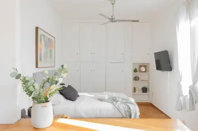 a white living room with a couch and a tv at Governo Central Apartment in Rome
