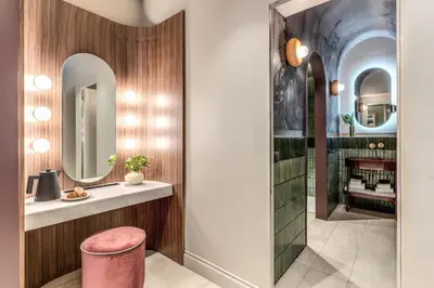 a dressing room with a pink stool and mirrors at Dimora Coppelle - Adults Only in Rome