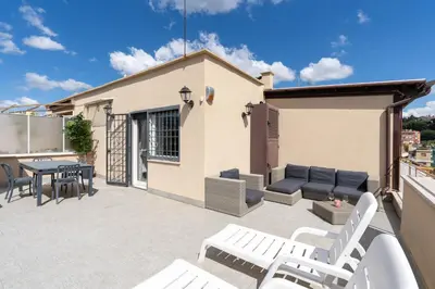 a patio with white chairs and a table on a balcony at Stella su San Pietro in Rome