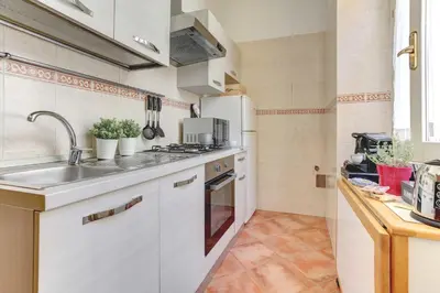 a kitchen with a sink and a white refrigerator at Colosseo - MecenStudio - Home and More in Rome