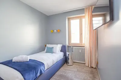 a small bedroom with a bed and a window at Vatican Exclusive Penthouse w Terrace and Parking in Rome