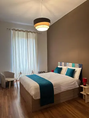 a bedroom with a large bed and a large window at Dreamingrome in Rome