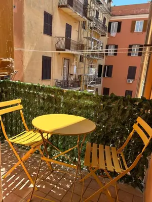 a yellow table and chairs on a balcony at Dreamingrome in Rome