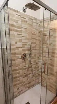 a shower with a shower head in a bathroom at Re di Roma Living in Rome