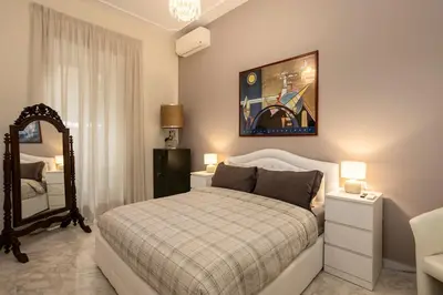 a bedroom with a white bed and a mirror at Domus Vespignani in Metro Lodi e San Giovanni - The Bright Spot in Rome