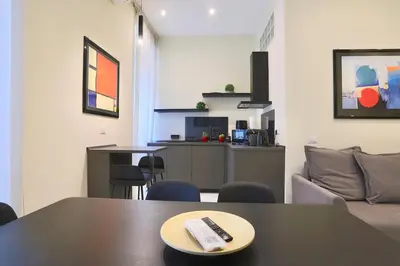 a living room with a table with a remote control on it at Domus Vespignani in Metro Lodi e San Giovanni - The Bright Spot in Rome