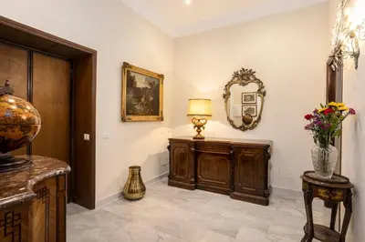 a hallway with a table with a lamp and a mirror at Domus Vespignani in Metro Lodi e San Giovanni - The Bright Spot in Rome