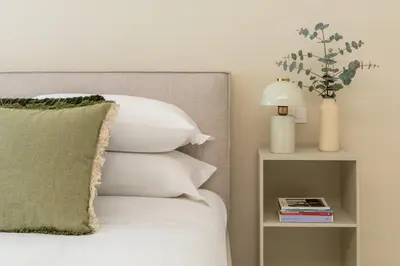 a bed with white pillows and a side table at Casa Green by Hili in Rome