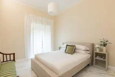a white bedroom with a bed and a window at Casa Green by Hili in Rome