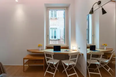 a dining room with a table and chairs and a window at Coronari Navona luxury 1 bedroom 2 bathrooms in Rome