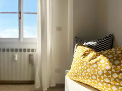 a room with two pillows on a bed with a window at Yellow Sweet Home in Rome