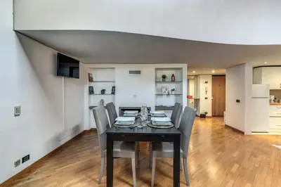 a dining room with a black table and chairs at Massimo 60 apartment by Roman Dreams in Rome