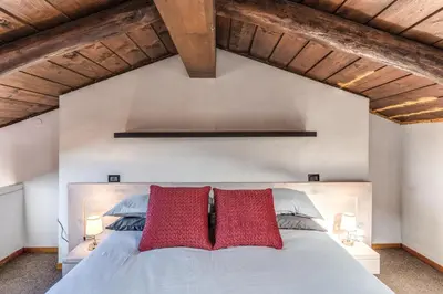 a bedroom with a bed with two red pillows at Massimo 60 apartment by Roman Dreams in Rome