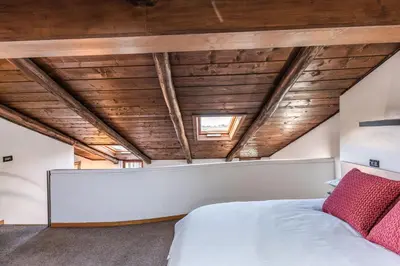a bedroom with a white bed and wooden ceilings at Massimo 60 apartment by Roman Dreams in Rome