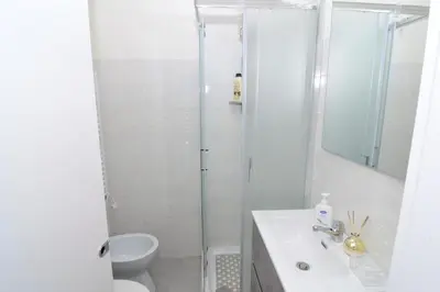 a kitchen with a white refrigerator and a table at Roma Metro Apartment in Rome
