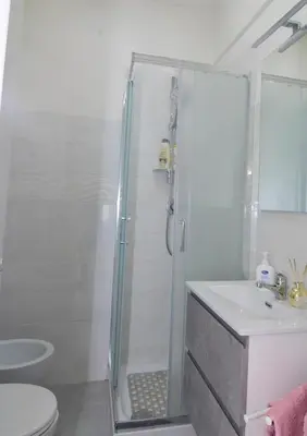 a white kitchen with a sink and a table at Roma Metro Apartment in Rome