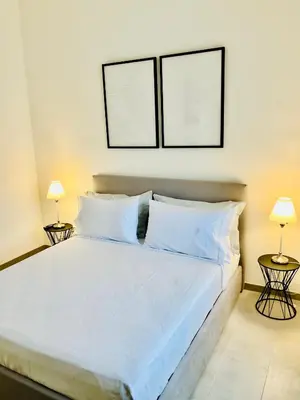 a bedroom with a large bed with two lamps at Palmira house in Rome