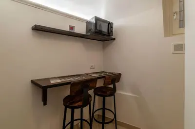 a small bar with two stools and a microwave at Domus Aureliano in Rome