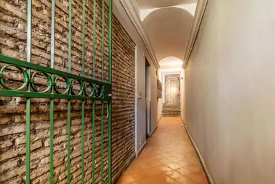 a hallway with a brick wall and a green gate at Domus Aureliano in Rome