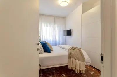 a white bedroom with a bed and a window at Grazia Appartamento Moderno & Chic a Tiburtina in Rome