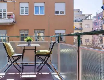 a balcony with a table and chairs and a building at Grazia Appartamento Moderno & Chic a Tiburtina in Rome