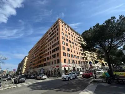 a tall building on a city street with cars parked at Urban Retreat Steps from the Metro in Rome