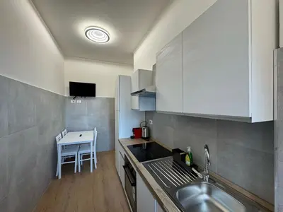 a small kitchen with a sink and a table at Urban Retreat Steps from the Metro in Rome