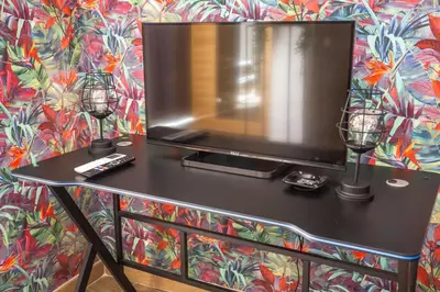 a table with two candles and a tv on a wall at Eco Retreat -Sauna & Garden in Rome