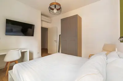 a bedroom with a white bed and a tv at Design Apartment, near Tiburtina Station in Rome
