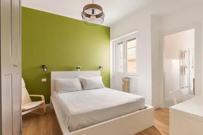 a bedroom with a green wall and a bed at Design Apartment, near Tiburtina Station in Rome