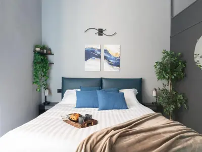 a bedroom with a large white bed with blue pillows at The Best Rent - Modern One-Bedroom Apartment in Trastevere in Rome