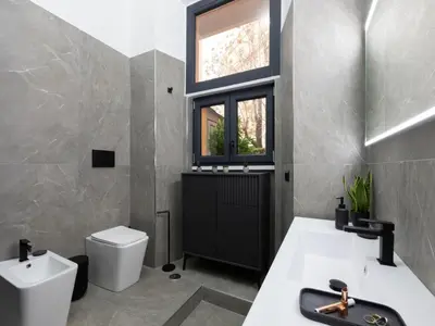 a bathroom with a toilet and a sink and a window at The Best Rent - Modern One-Bedroom Apartment in Trastevere in Rome