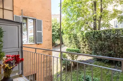 a balcony with a vase of flowers next to a building at The Best Rent - Modern One-Bedroom Apartment in Trastevere in Rome