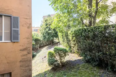 a building next to a hedge with a window at The Best Rent - Modern One-Bedroom Apartment in Trastevere in Rome