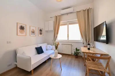 a living room with a white couch and a table at Cozy Studio Steps from Metro station in Rome